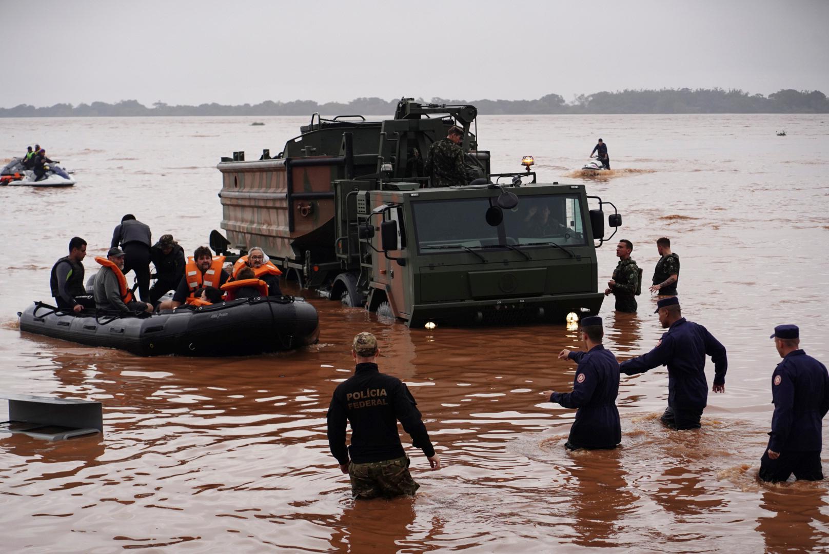 Soldater och polis evakuerar invånare i översvämningsdrabbade Porto Alegre i lördags. Foto: Carlos Macedo/AP/TT